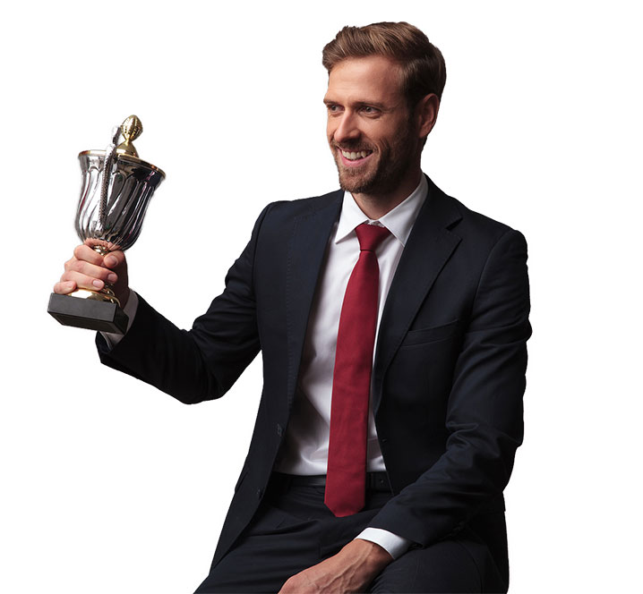 well dressed man in a suit holding up a cup trophy for corporate award