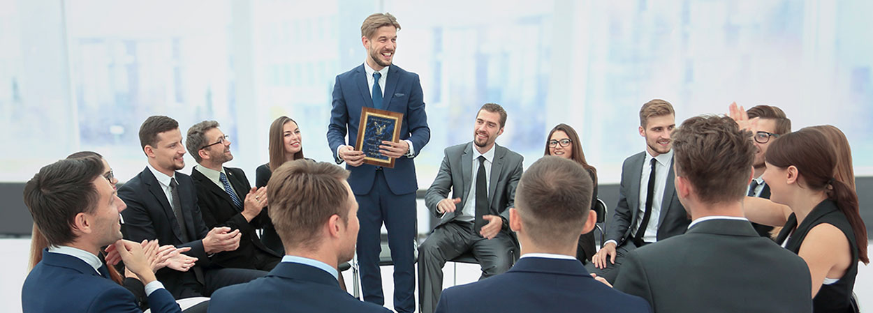 Business man accepting a corporate award plaque from other business people